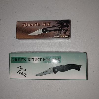 Four different pocketknives and a lasered antelope on tile