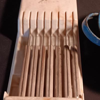 Blue enamelware dish with a set of vintage Zylco Freeze knives in a hanging bakelite case