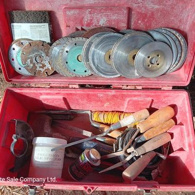 Red plastic toolbox with an assortment of tools and blades