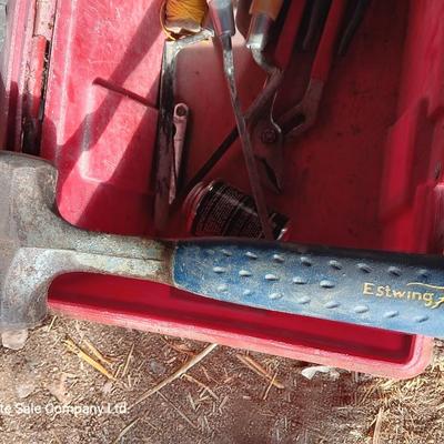 Red plastic toolbox with an assortment of tools and blades