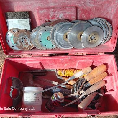 Red plastic toolbox with an assortment of tools and blades
