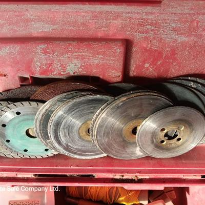 Red plastic toolbox with an assortment of tools and blades