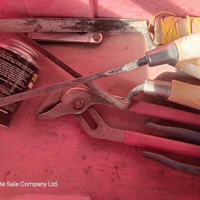 Red plastic toolbox with an assortment of tools and blades