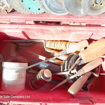 Red plastic toolbox with an assortment of tools and blades