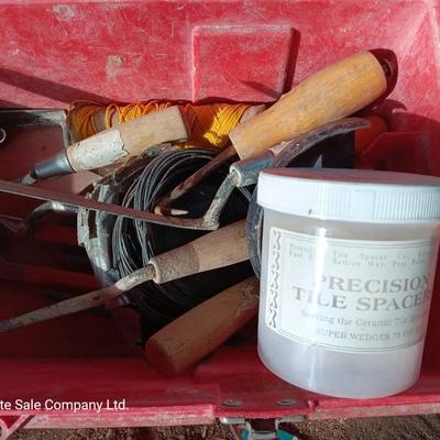 Red plastic toolbox with an assortment of tools and blades