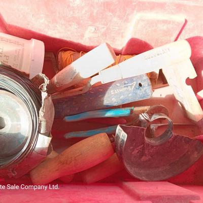 Red plastic toolbox with an assortment of tools and blades