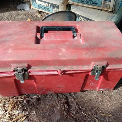 Red plastic toolbox with an assortment of tools and blades