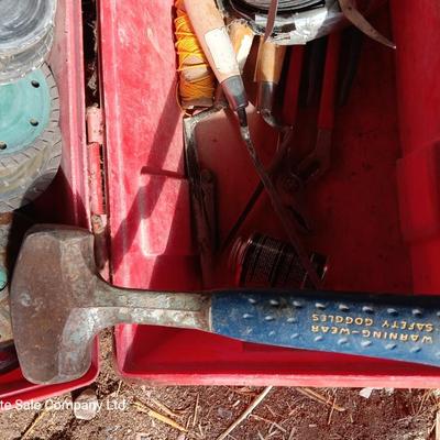 Red plastic toolbox with an assortment of tools and blades