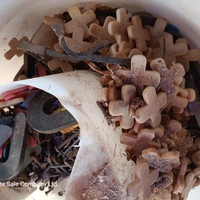 Box of dark colored tile with buckets of tile spacers and other hardware