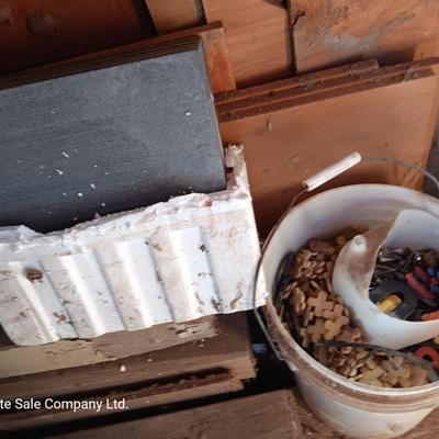 Box of dark colored tile with buckets of tile spacers and other hardware