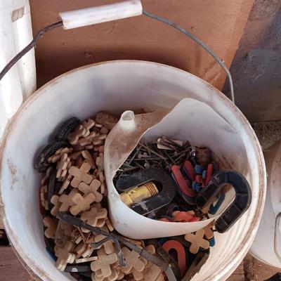 Box of dark colored tile with buckets of tile spacers and other hardware