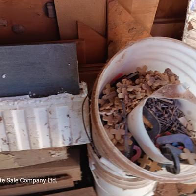 Box of dark colored tile with buckets of tile spacers and other hardware