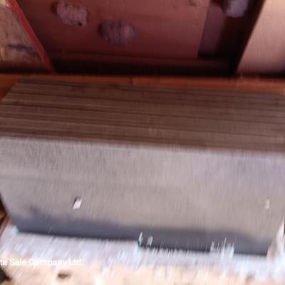 Box of dark colored tile with buckets of tile spacers and other hardware