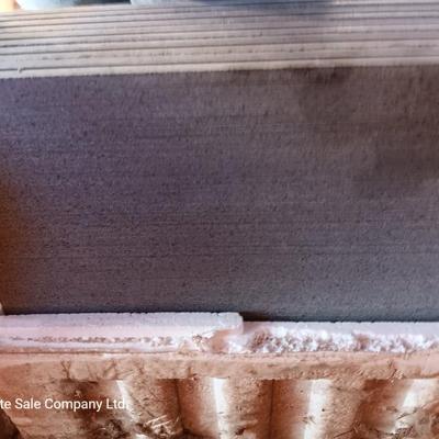 Box of dark colored tile with buckets of tile spacers and other hardware