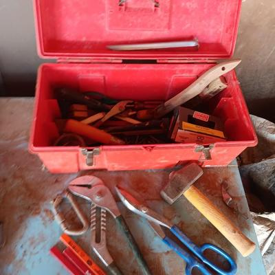 Red plastic toolbox with a variety of tools