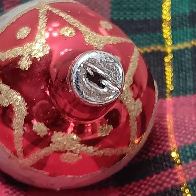 Two Christmas ornaments - one with tinsel inside and one that is indented.