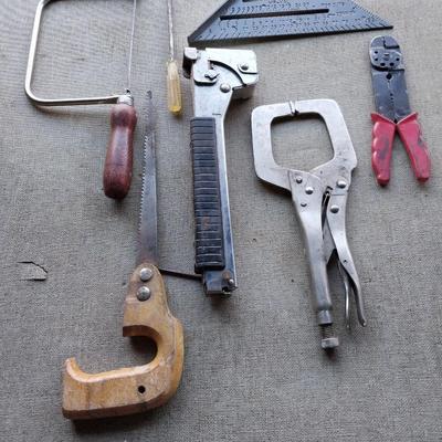 Assortment of tools - saws, wire cutters- clamp locking pilers - square and stapler