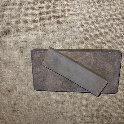 Eight White metal shelf brackets with an assortment of hardware and sharpening stones