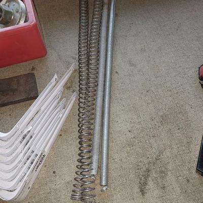 Eight White metal shelf brackets with an assortment of hardware and sharpening stones