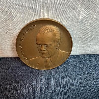 Lot 76, USS, John F Kennedy belt buckle + 2 paperweight coins