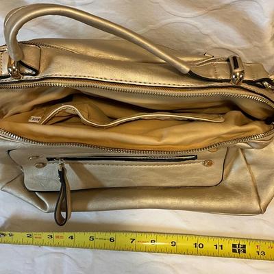 Beautiful champagne colored purse, with dark colored hard vinyl