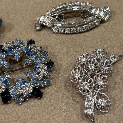 5 blue, black & clear stone brooches