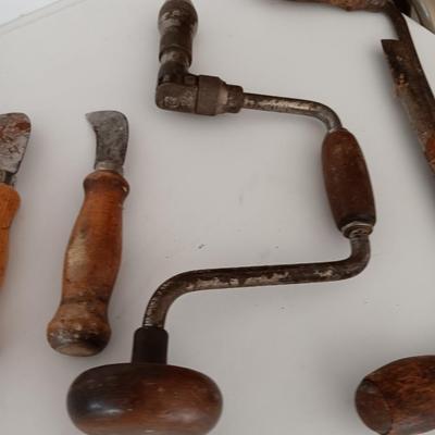 Variety of vintage hand tools - wooden handles - saw - drill - draw knife