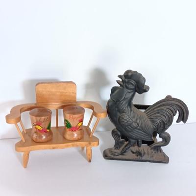 Cast Iron Rooster napkin holder with chicken theme salt & pepper on a bench.