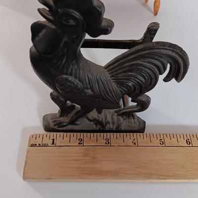 Cast Iron Rooster napkin holder with chicken theme salt & pepper on a bench.