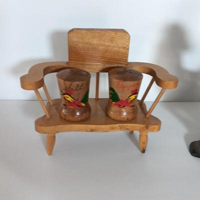 Cast Iron Rooster napkin holder with chicken theme salt & pepper on a bench.