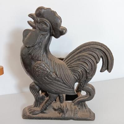 Cast Iron Rooster napkin holder with chicken theme salt & pepper on a bench.