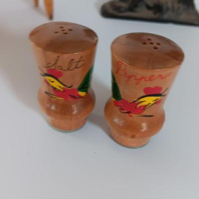 Cast Iron Rooster napkin holder with chicken theme salt & pepper on a bench.
