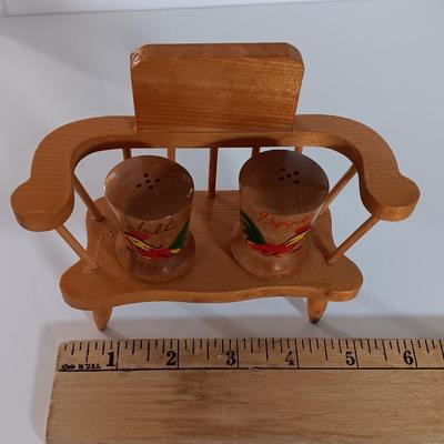Cast Iron Rooster napkin holder with chicken theme salt & pepper on a bench.