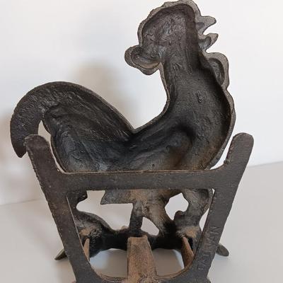 Cast Iron Rooster napkin holder with chicken theme salt & pepper on a bench.