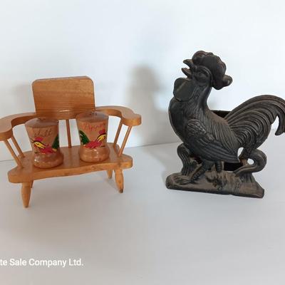 Cast Iron Rooster napkin holder with chicken theme salt & pepper on a bench.