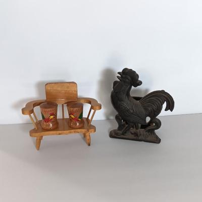 Cast Iron Rooster napkin holder with chicken theme salt & pepper on a bench.