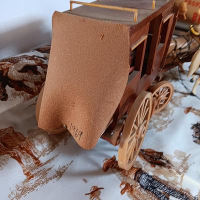 Vintage wooden covered wagon with horse team and wild west cowboy fabric