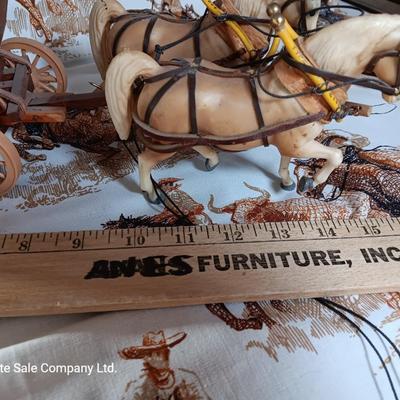 Vintage wooden covered wagon with horse team and wild west cowboy fabric