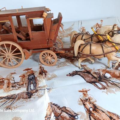 Vintage wooden covered wagon with horse team and wild west cowboy fabric