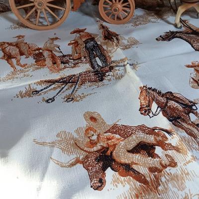 Vintage wooden covered wagon with horse team and wild west cowboy fabric