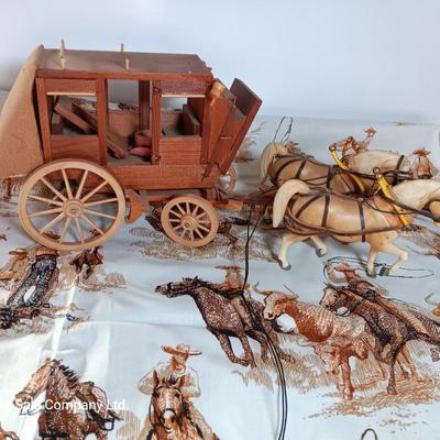 Vintage wooden covered wagon with horse team and wild west cowboy fabric