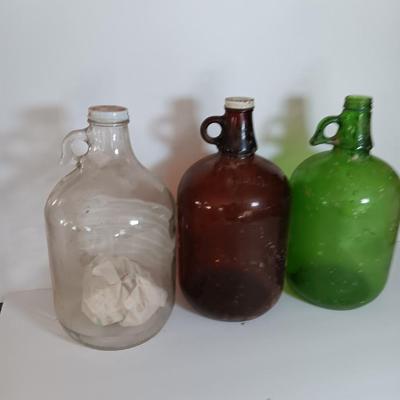 Three vintage glass gallon jugs each with a handle