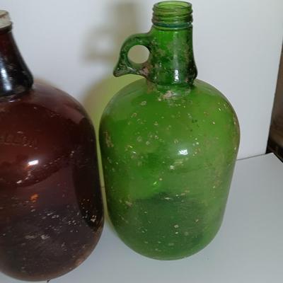 Three vintage glass gallon jugs each with a handle