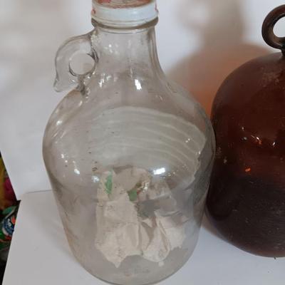 Three vintage glass gallon jugs each with a handle