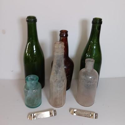 Antique glass bottles and two bottle openers