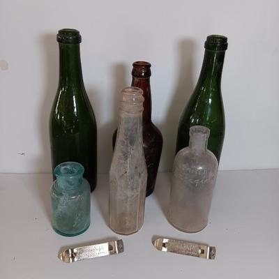 Antique glass bottles and two bottle openers