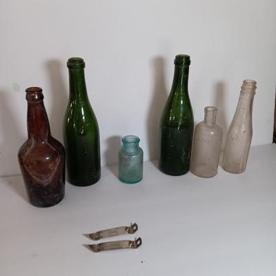 Antique glass bottles and two bottle openers