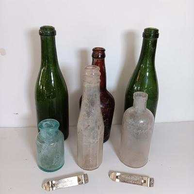 Antique glass bottles and two bottle openers