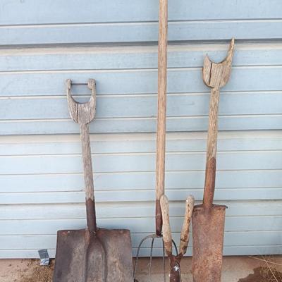 Two antique shovels with wood handles an old pitchfork and some trimmers