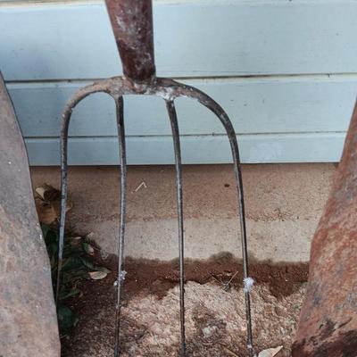Two antique shovels with wood handles an old pitchfork and some trimmers
